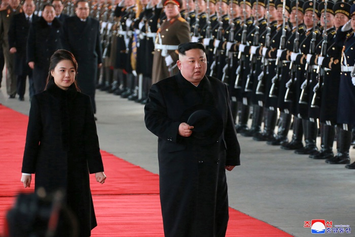 North Korean leader Kim Jong Un (right) reviews an honor guard with his wife Ri Sol Ju before departing to China from Pyeongyang on Jan. 8. (Yonhap News)